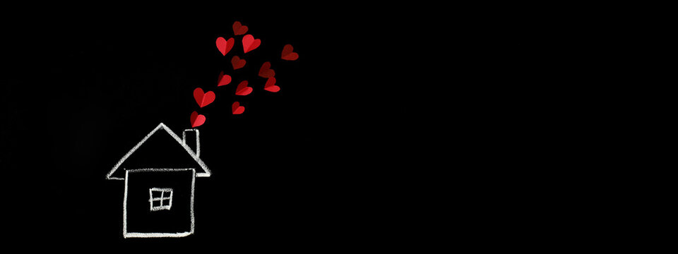 The house is drawn on a black board. The concept of love in the family. St. Valentina. Family day. Investment in housing.