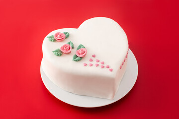 Heart cake for St. Valentine's Day, Mother's Day, or Birthday, decorated with roses and pink sugar hearts on red background	