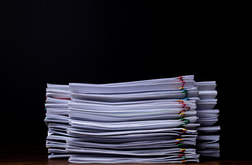 Stack overload document report paper with colorful paperclip place on black background with copy space