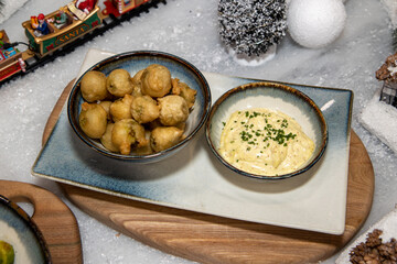 A delicious plate of cooked deep fried Brussels sprouts on a Christmas themed background