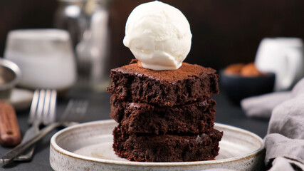 Chocolate brownies with vanilla ice cream scoop on top. Sweet rich dessert
