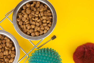 Pet accessories, food, toys. Top view on yellow background