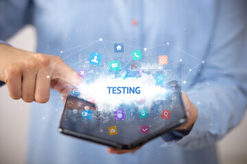 Businessman holding a foldable smartphone with TESTING inscription, technology concept