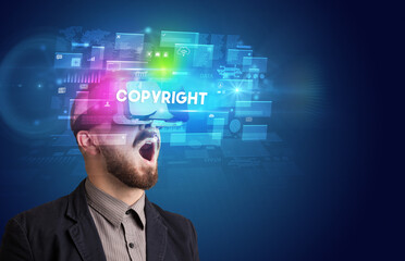 Businessman looking through Virtual Reality glasses with COPYRIGHT inscription, innovative security concept
