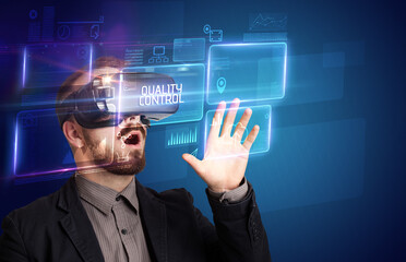 Businessman looking through Virtual Reality glasses with QUALITY CONTROL inscription, new technology concept
