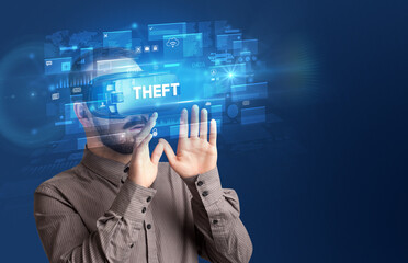 Businessman looking through Virtual Reality glasses with THEFT inscription, innovative security concept
