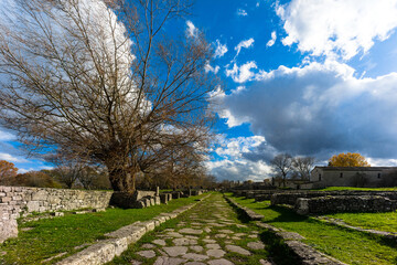 Altilia, Sepino, Molise, Italy, 12/05/2020: the Decumanum, on the sides the walls of the artisan...