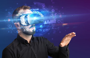 Businessman looking through Virtual Reality glasses with ARCHITECTURE inscription, innovative technology concept