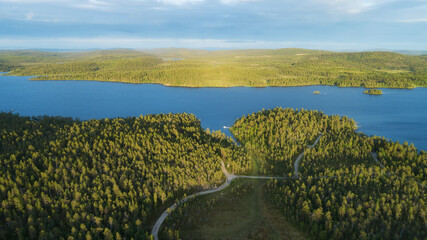 Aerial view of cabins, blue lake with green forests on a sunny summer day in Finland. Inari lake, Lapland.