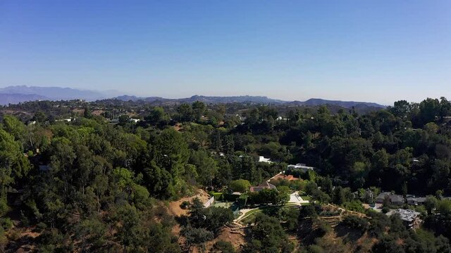 Aerial rising shot of a hills community above Sherman Oaks with fresh water reservoir. HD at 60 FPS.