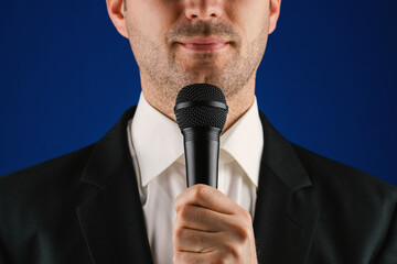 Mann hält eine Rede mit Mikrofon in der Hand