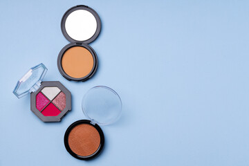 Set of eyeshadows on blue background close up