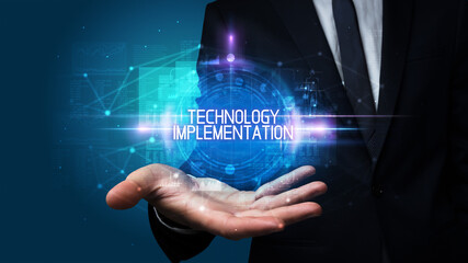 Man hand holding TECHNOLOGY IMPLEMENTATION inscription, technology concept
