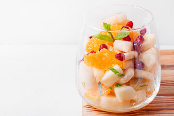 Fruit salad with apple, pear, banana, orange, pomegranate seeds and mint served in the portion glass. Sugar free dessert