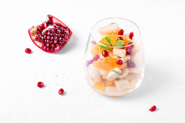 Fruit salad with apple, pear, banana, orange, pomegranate seeds and mint served in the portion glass. Sugar free dessert