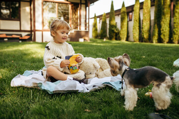 Kid play with teddy bear in the garden