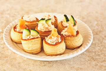 Savory VolAuVents Pastry stuffed with seafood cream and decorated with a salmon and cucumber. Delicious pastries finger food.