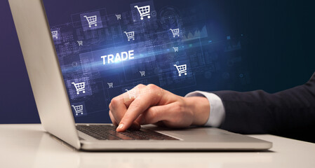 Businessman working on laptop with TRADE inscription, online shopping concept