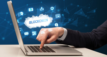 Businessman working on laptop with BLOCKCHAIN inscription, modern technology concept