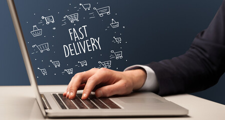 Businessman working on laptop with FAST DELIVERY inscription, online shopping concept