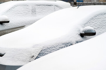 Snowy streets from a blizzard. Cars under the snow after a snowfall