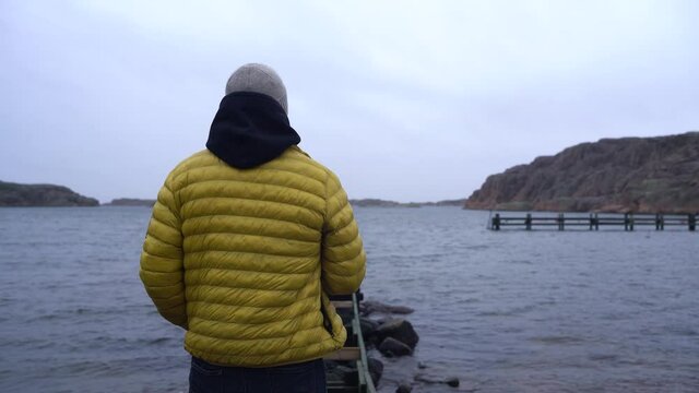 White guy looking at the ocean in the winter