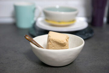 A portion of ice cream in a bowl on the table in the kitchen