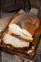 Poppy seed bun. Bread with poppy seeds on a wooden background. Homemade cakes with poppy seeds