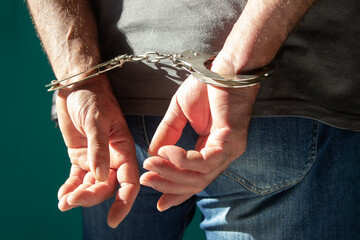 Man with his hands handcuffed in criminal concept