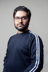 A young man standing in a room looking sideways
