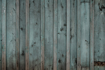 fragment of a fence made of old wooden boards with remnants of paint and nails, natural texture, background