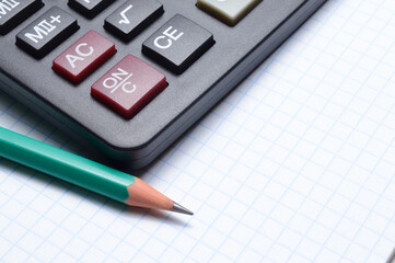 calculator, notebook and pencil lie together. close-up.