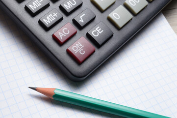 calculator, notebook and pencil lie together. close-up.