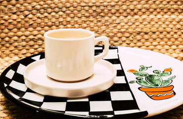 Herbal tea in cup on handmade ceramic plate. Healthy herbal tea. Hand drawing cactus flower.