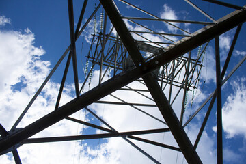 electric tower, bottom-up view, with blue sky and clouds