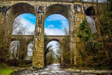 Fototapeta na wymiar The River Ceiriog flowing through the aqueduct and the railway viaduct at Chirk, Wales