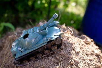 Toy plastic tank driving on the road and smoking