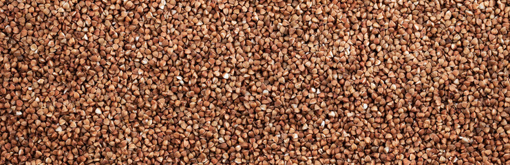 Background and texture of dry brown buckwheat. View from above.