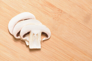 Sliced fresh champignons on a wooden cutting board