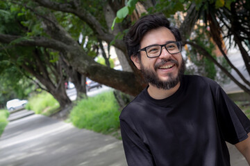 smiling mexican man with beard and glasses at park