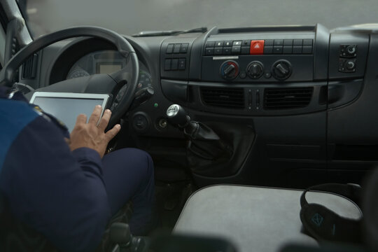 man holding  tablet  computer. Tablet with navigation in truck or bus cabin during drive. no face.