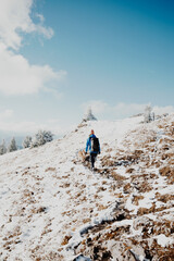 Wandernde Frau mit Hund in verschneiter Landschaft am Berg