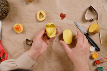 heart shaped potato stamp on craft paper. The process of decorating a gift for Valentine's Day....