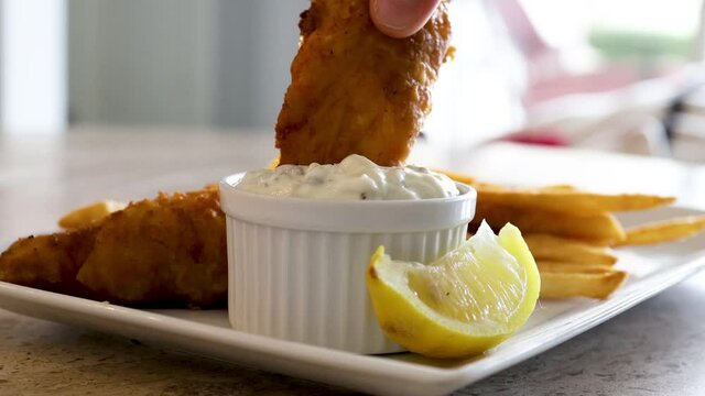 Dipping Fried Cod Into Tarter Sauce