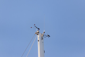 Top of the yacht's mast. Equipment on the top of the mast. Wind meter and weather indicator.