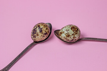 Quail eggs on a pink background. Healthy food. Quail eggs lie on teaspoons