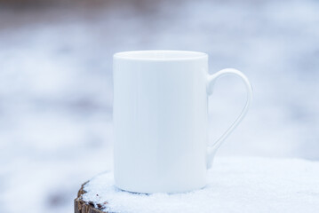 Obraz na płótnie Canvas White porcelain coffee cup, mug on outdoor frozen snow