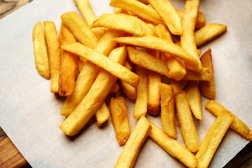 French fries on white paper background, close-up