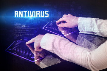 Hand touching digital table with ANTIVIRUS inscription, new age security concept