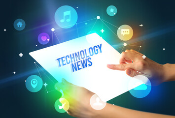 Holding futuristic tablet with TECHNOLOGY NEWS inscription, new technology concept